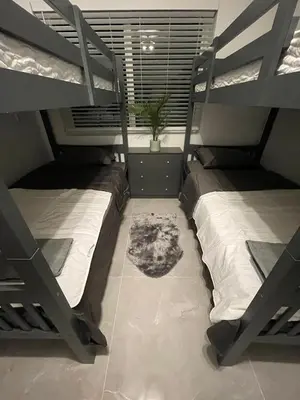 a bedroom with two bunk beds and a potted plant at USA Star Hostel in Hallandale Beach