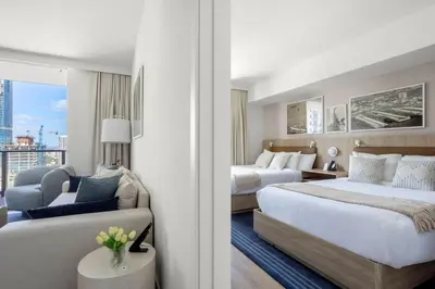 a hotel room with two beds and a couch at 2002 One bedroom unit for 4 Ppl next to Kaseya Center with Gym and Pool in Downtown Miami in Miami