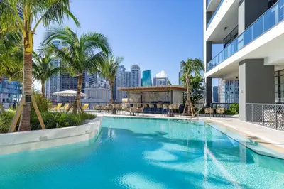 a swimming pool with palm trees and a building at 2002 One bedroom unit for 4 Ppl next to Kaseya Center with Gym and Pool in Downtown Miami in Miami