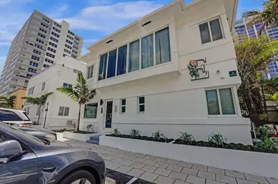 a white house with cars parked in front of it at Eden Collection Studio Steps to Beach in Fort Lauderdale