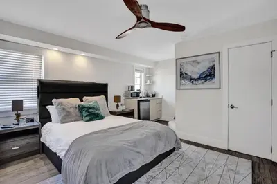 a bedroom with a bed and a ceiling fan at Eden Collection Studio Steps to Beach in Fort Lauderdale