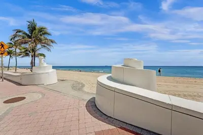 a sandy beach with palm trees and the ocean at Eden Collection Studio Steps to Beach in Fort Lauderdale