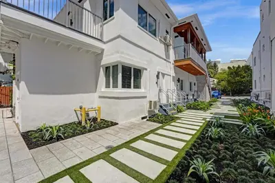 a walkway in front of a white building at Eden Collection Studio Steps to Beach in Fort Lauderdale