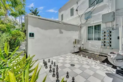a backyard with a chess board on a patio at Eden Collection Studio Steps to Beach in Fort Lauderdale