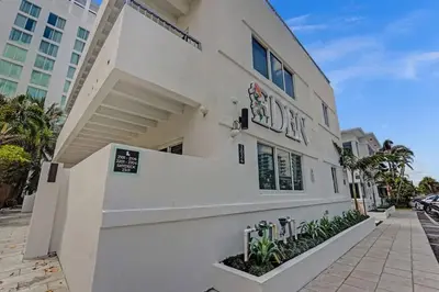 a white building with a sign on the side of it at Eden Collection Studio Steps to Beach in Fort Lauderdale