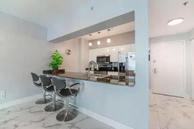 a kitchen with a counter and stools at Stylish Brickell Penthouse with Exclusive Perks in Miami