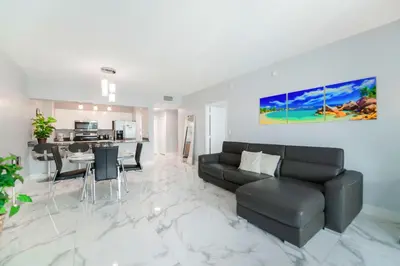 a living room with a black couch and a table at Stylish Brickell Penthouse with Exclusive Perks in Miami