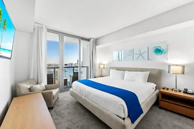 a bedroom with a large bed and a large window at Coastal Luxe Residences - Premium Suites with Pool and Water Views in Hallandale Beach