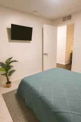 a bedroom with a bed and a tv on the wall at Santamaria Fort Lauderdale Airport in Fort Lauderdale
