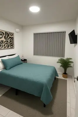 a bedroom with a green bed and a plant at Santamaria Fort Lauderdale Airport in Fort Lauderdale