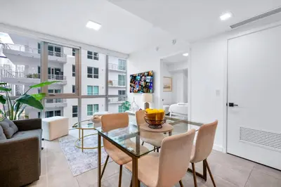 a living room with a glass table and chairs at Modern Comfort by the Beautiful Bay in Miami