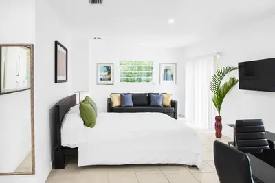 a white bedroom with a white bed and a couch at Buena Vista-Miami Designer Apartment # 3 in Miami