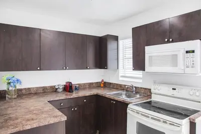 a kitchen with wooden cabinets and a white microwave at Buena Vista-Miami Designer Apartment # 3 in Miami
