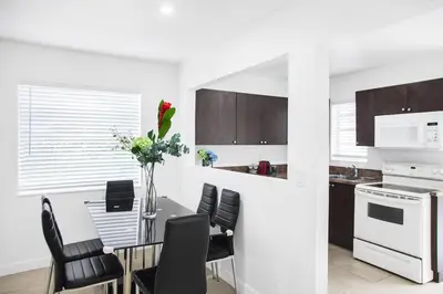 a kitchen with a dining room table with black chairs at Buena Vista-Miami Designer Apartment # 3 in Miami