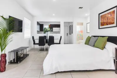 a white bedroom with a large bed and a dining room at Buena Vista-Miami Designer Apartment # 3 in Miami