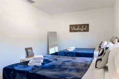 a bedroom with two beds and a mirror at Family-Friendly Townhouse Getaway Near Top Attractions in Golden Glades