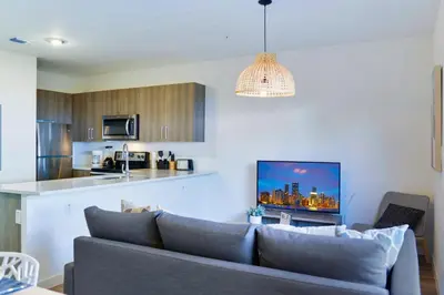 a living room with a couch and a kitchen at Family-Friendly Townhouse Getaway Near Top Attractions in Golden Glades