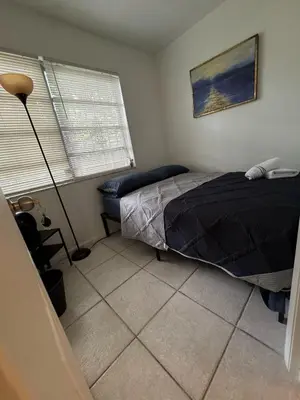 a bedroom with a bed and a lamp in it at Layover Miami International Airport in Miami