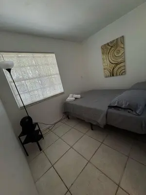 a bedroom with a bed and a lamp in it at Layover Miami International Airport in Miami