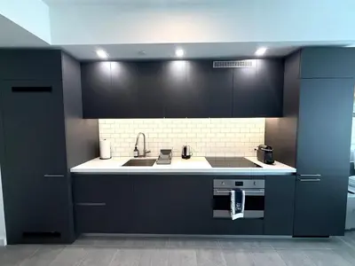 a kitchen with black cabinets and a sink at Stunning City Views Studio Gym Pool in Miami