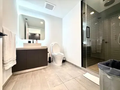 a bathroom with a toilet and a sink and a shower at Stunning City Views Studio Gym Pool in Miami