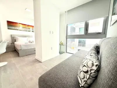 a bedroom with a bed and a large window at Stunning City Views Studio Gym Pool in Miami