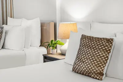 a white bed with white pillows and a couch at Studio Residence at Roney -1128 in Miami Beach