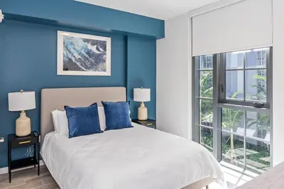 a bedroom with blue walls and a bed with blue pillows at The Juliet VII Vibe 8702 in Miami