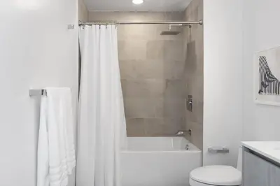 a bathroom with a white shower curtain and a toilet at The Juliet VII Vibe 8702 in Miami