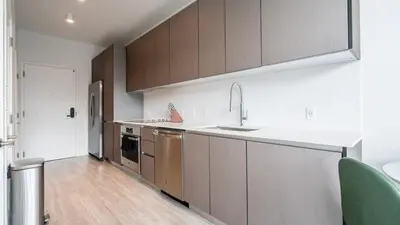 a kitchen with brown cabinets and a white counter top at The Juliet IX Vibe 8707 in Miami
