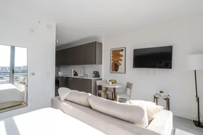 a white living room with a couch and a kitchen at The Juliet XII Vibe 8745 in Miami