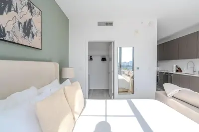 a white bedroom with a bed and a kitchen at The Juliet XII Vibe 8745 in Miami