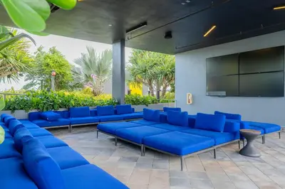 a waiting room with blue couches and a flat screen tv at The Juliet XII Vibe 8745 in Miami