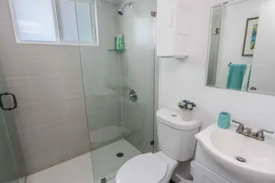 a bathroom with a shower and a toilet and a sink at Mimo Bungalows By Renzzi in Miami