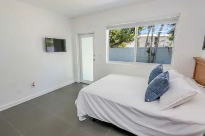 a white bedroom with a bed with pillows and a window at Mimo Bungalows By Renzzi in Miami