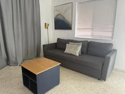 a living room with a gray couch and a table at Wynwood Bungalows By Renzzi in Miami