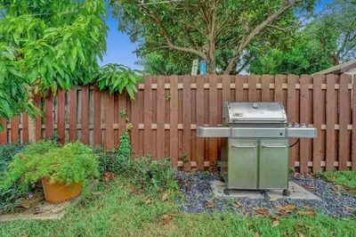 a grill in a yard next to a fence at Newly Renovated w Heated Saltwater Pool & Hot Tub in Hollywood