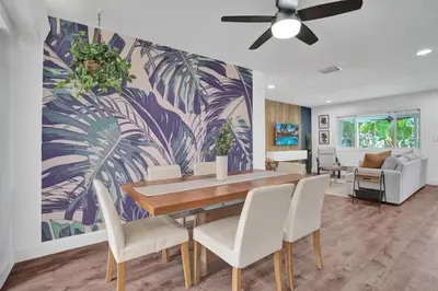 a dining room with a table and white chairs at Newly Renovated w Heated Saltwater Pool & Hot Tub in Hollywood