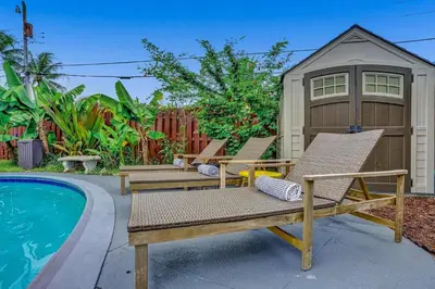 a couple of chairs sitting next to a pool at Newly Renovated w Heated Saltwater Pool & Hot Tub in Hollywood