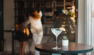 a martini glass sitting on a wooden table with a cactus at San Juan Hotel Miami Beach in Miami Beach