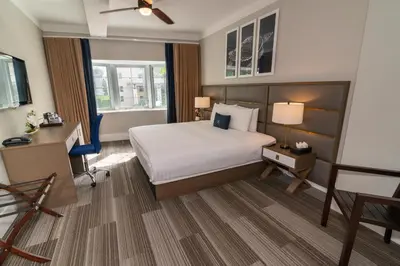 a hotel room with a bed and a desk and window at San Juan Hotel Miami Beach in Miami Beach