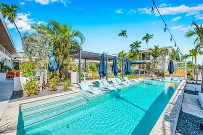 a swimming pool with chairs and umbrellas at Waterfront Heated pool Lime Key Two in Fort Lauderdale