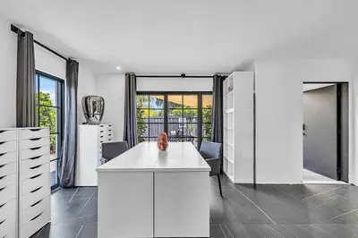 a kitchen with a white island in a room with windows at Family Vacation Home in Miami