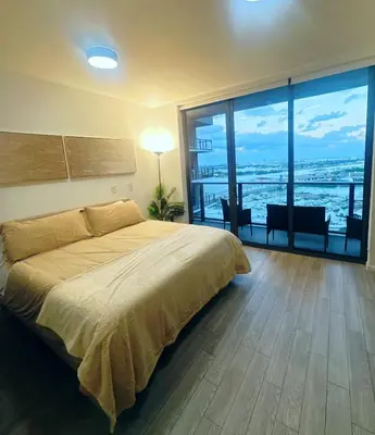 a bedroom with a large bed and a large window at Luxe Ventures Miami in Miami