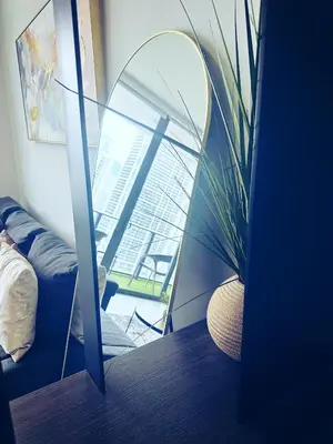 a mirror in a room with a plant next to it at Luxe Ventures Miami in Miami
