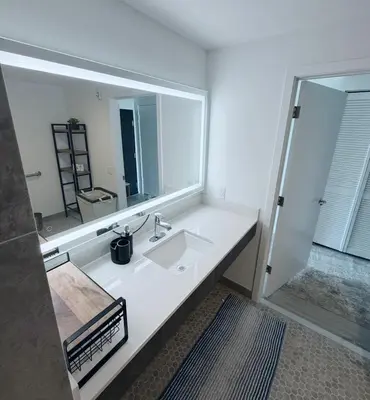 a bathroom with a sink and a large mirror at Luxe Ventures Miami in Miami