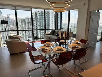 a living room with a table and chairs and a couch at Luxury 2BR Skyline Balcony Free Parking by Palermo Home Miami in Miami