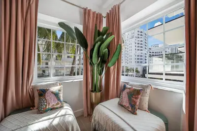 a room with two beds and a window with a plant at Le Particulier Miami in Miami Beach