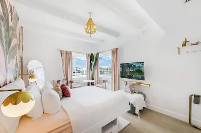 a white bedroom with a bed and a window at Le Particulier Miami in Miami Beach