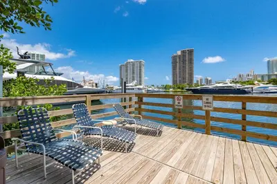 two chairs sitting on a deck with a view of the water at Yacht Club Miami Suite 1BR and 1BA with Pool FREE Parking Gym & Jacuzzi in South Island